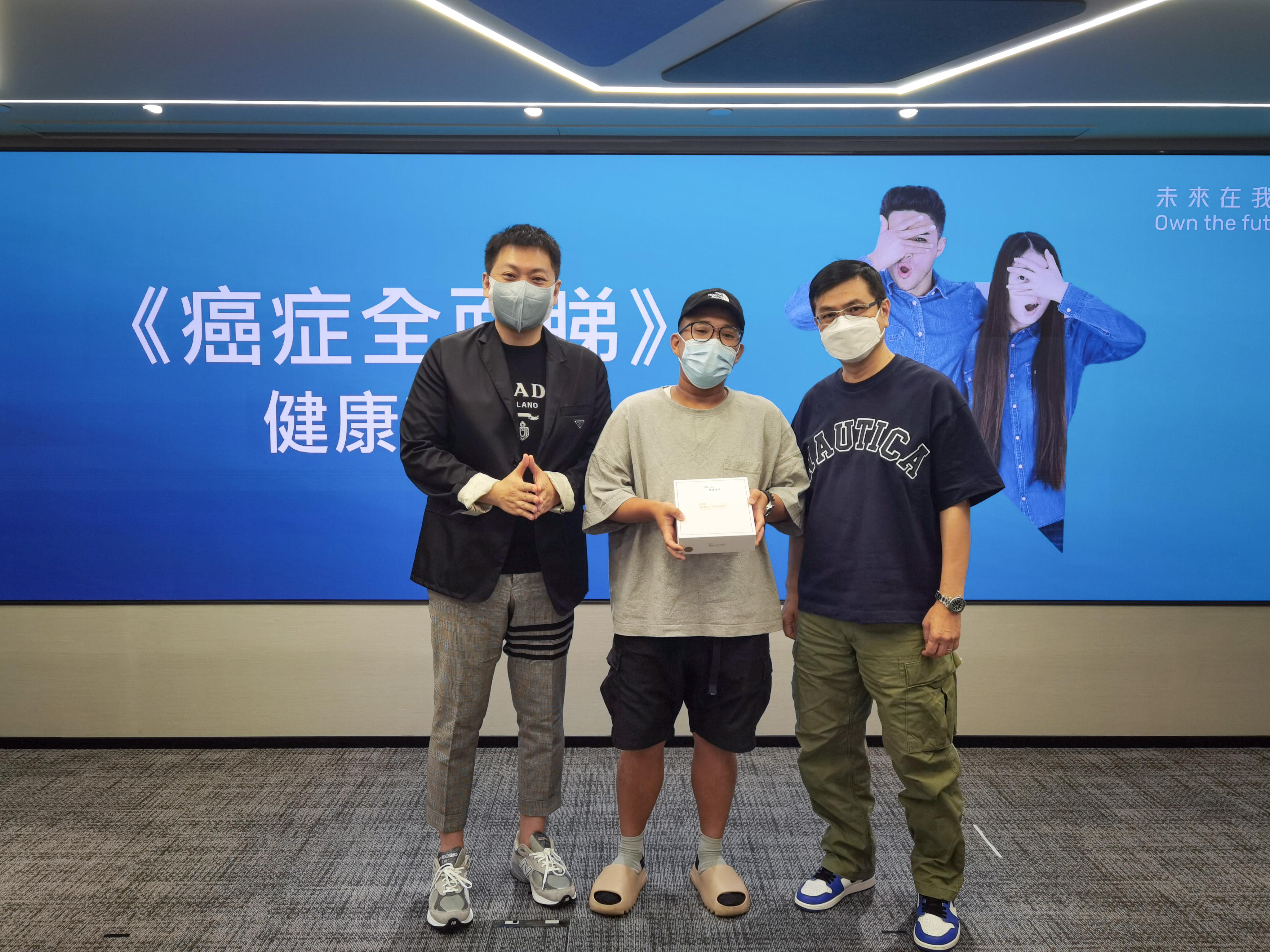 萬通保險副首席業務總監葉志堃先生（左）向《癌症全面睇》健康講座大抽獎幸運兒送上OTO Nectonic脈衝按摩器，並與幸運兒及其理財顧問合照。